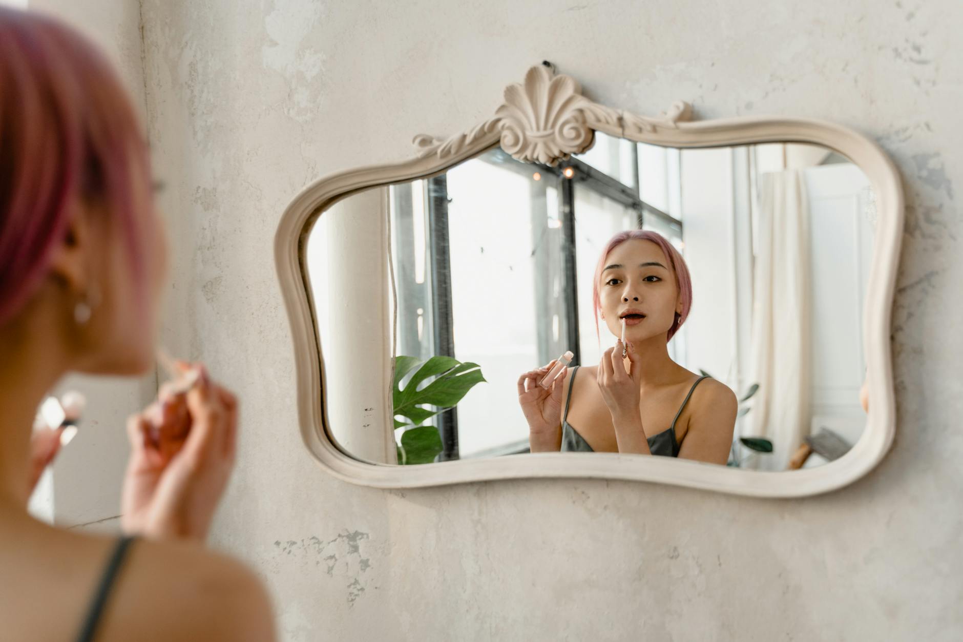 Person sitting at desk looking thoughtful with achievement certificates on wall behind them